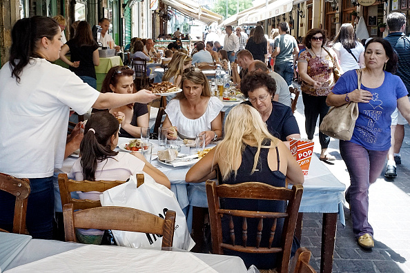 Des touristes à la terrasse d'un restaurant traditionnel à Monastiraki, Athènes, Grèce. (Photo by Milos Bicanski/Getty Images)