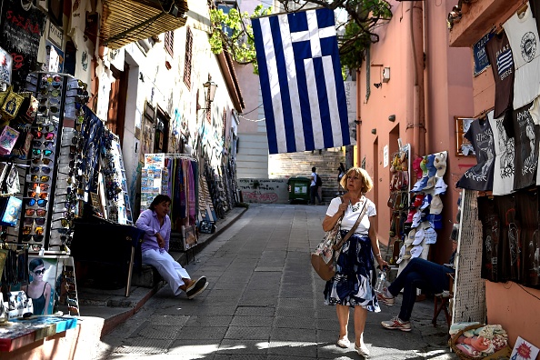 Un touriste marche sous un drapeau grec au centre d'Athènes. (ELEFTHERIOS ELIS/AFP/Getty Images)
