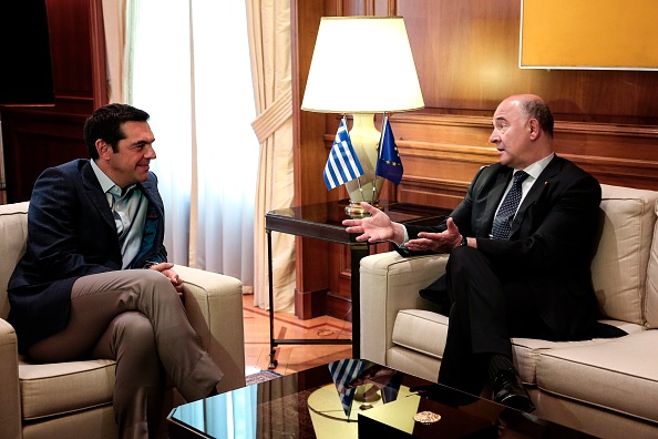 Le Commissaire aux Affaires européennes Pierre Moscovici (D) avec le Premier ministre grec Alexis Tsipras (G) le 25 juillet à Athènes. (ANGELOS TZORTZINIS/AFP/Getty Images)