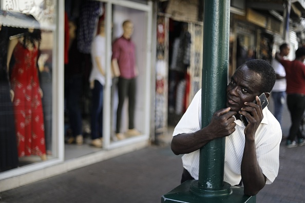 Un migrant africain utilisant son smartphone dans le quartier de  Neve Shaanan au sud de Tel-Aviv. (MENAHEM KAHANA/AFP/Getty Images)