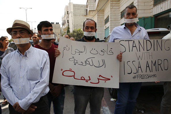 Des dizaines de militants rassemblés avec du ruban adhésif sur la bouche devant les bureaux du parquet pour protester contre la détention de Issa Amro. (HAZEM BADER/AFP/Getty Images)