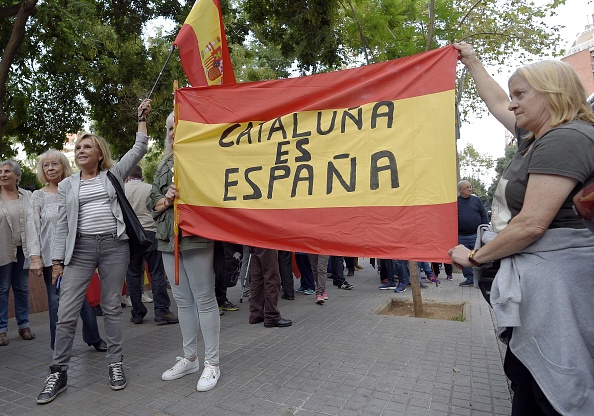 Des manifestants contre l'indépendance de la Catalogne, brandissent un drapeau "La Catalogne c'est l'Espagne" , devant l'Assemblée nationale catalane (ANC) à Barcelone, le 22 Septembre 2017.  
(LLUIS GENE/AFP/Getty Images)