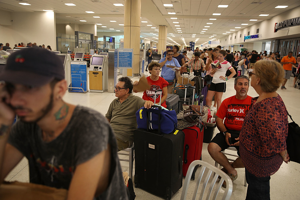 Des gens font la queue pour quitter l'île après le passage de l'ouragan Maria, le 25 septembre à l'aéroport de Porto Rico.   (Photo by Joe Raedle/Getty Images)