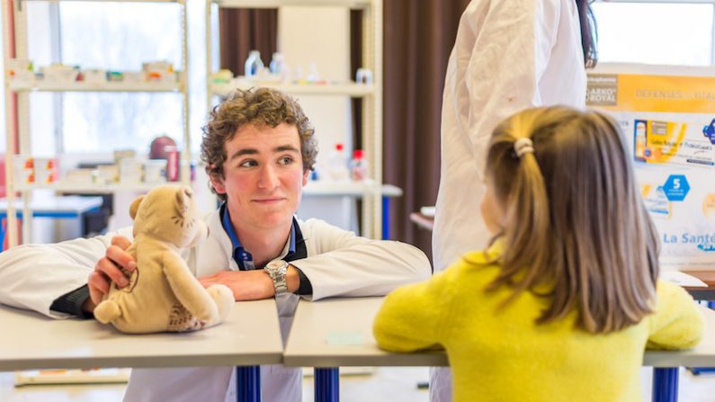 Un étudiant en médecine explique les soins à une enfant, dans le cadre de l'opération Hôpital des nounours à Caen. Des études à risque de souffrance psychique. (Gaëtan Zarforoushan/Flickr, CC BY-SA)