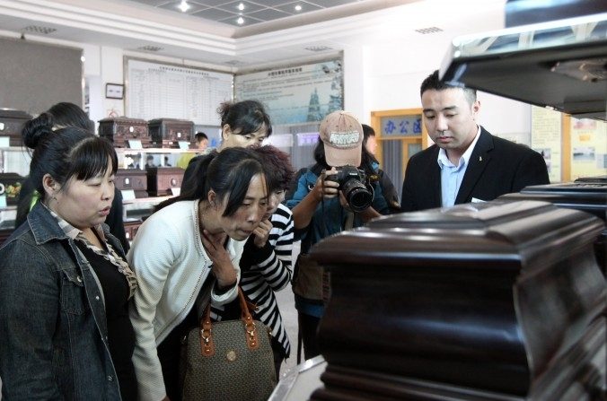Zhang Jing (seconde à gauche) choisissant une boîte pour contenir les cendres de son mari Xia Junfeng, un vendeur de rue de 36 ans, à la Maison Funéraire de Dongling le 26 septembre 2013, à Shenyang, Chine. Xia Junfeng a été exécuté pour avoir tué deux officiers de régulation urbaine et en avoir blessé un autre en 2009. (ChinaFotoPress/Getty Images)