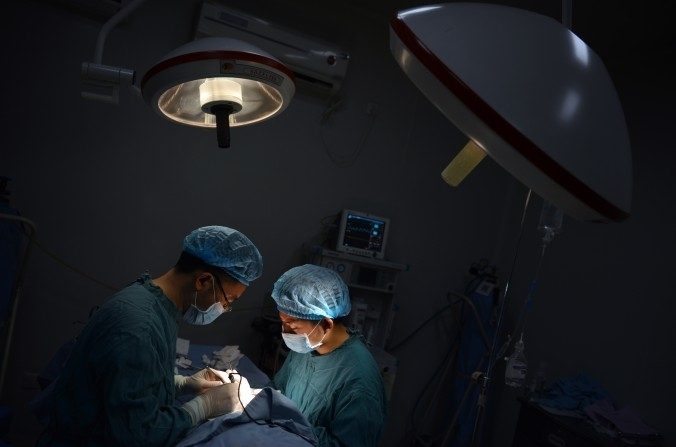 Deux chirurgients menant une opération de transplantation,dans le Sud Ouest de la Chine,à Chongqin, le 9 août 2013. (Peter Parks/AFP/Getty Images)