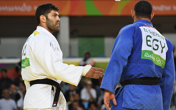 L'Israélien Or Sasson, médaillé olympique en 2016, tend la main à l'Égyptien Islam Elshehaby lors du match de judo des plus de 100 kg masculin des Jeux Olympiques de Rio 2016 à Rio de Janeiro le 12 août 2016. 
(TOSHIFUMI KITAMURA/AFP/Getty Images)