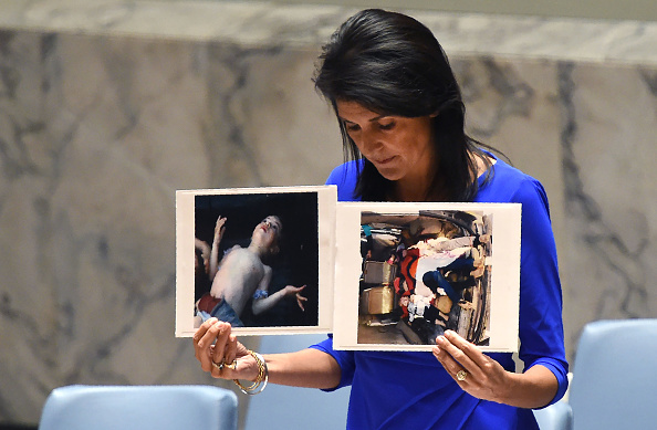 Nikki Haley, ambassadeur des États-Unis à l'ONU, tient des photos des victimes lors d'une réunion d'urgence du Conseil de sécurité des Nations Unies le 5 avril 2017 sur l'attaque chimique meurtrière présumée qui a tué des civils, dont des enfants, en Syrie. (TIMOTHY A. CLARY / AFP / Getty Images)