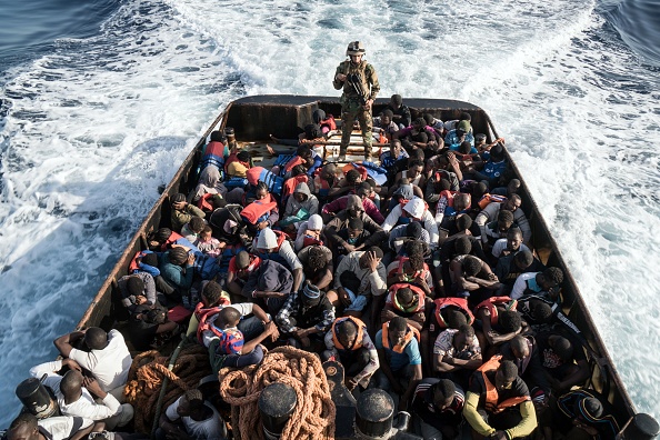 Un garde côte libyen se tient debout dans un bateau de sauvetage rempli de 147 migrants. (TAHA JAWASHI/AFP/Getty Images)