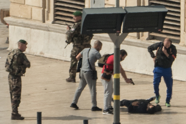 Un policier pointe son arme  sur un homme à terre après la tuerie au couteau à la gare Saint-Charles de Marseille le 1er octobre. 
(PAUL-LOUIS LEGER/AFP/Getty Images)