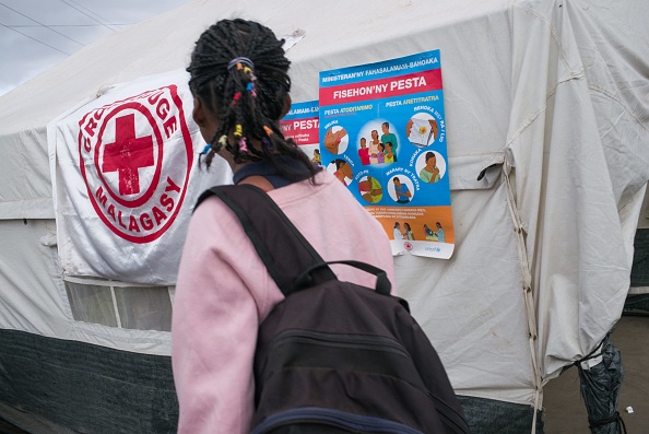 Un piéton franchit un point de contrôle sanitaire du ministère de la Santé et de la Croix-Rouge qui a pour mission d'informer les personnes quittant Antananarivo et de détecter potentiellement les cas suspects de peste. 
(RIJASOLO / AFP / Getty Images)