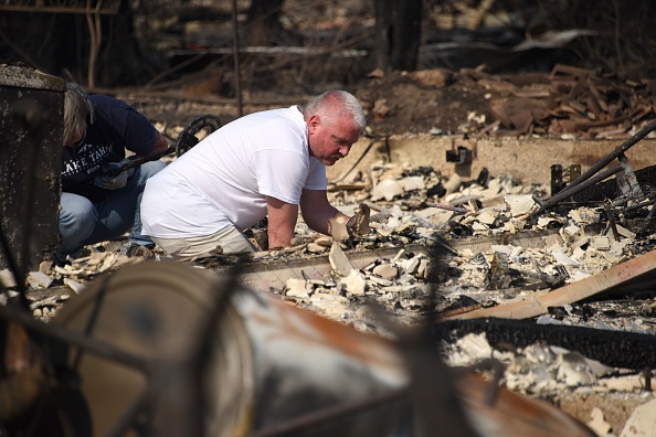 Un homme fouille les restes de sa maison dans l'espoir de trouver des objets précieux après que la maison de sa famille ait été détruite par un feu de forêt –
ROBYN BECK / AFP / Getty Images
