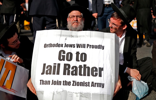 Jérusalem le 19 octobre 2017, un manifestant juif ultra-orthodoxe porte une pancarte disant "les juifs orthodoxes iront fièrement en prison plutôt que de rejoindre l'armée sioniste", lors d'une manifestation contre le recrutement des juifs religieux par l'armée israélienne. (THOMAS COEX / AFP / Getty Images)