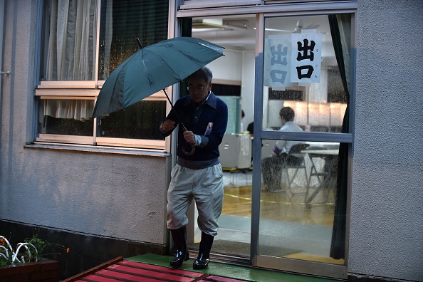 Un électeur japonais quitte un bureau de vote après avoir voté aux élections législatives japonaises à Tokyo le 22 octobre 2017. Des élections au Japon ont été organisées pour une élection anticipée, les conservateurs du Premier ministre Shinzo Abe devant croiser à une majorité confortable après une campagne dominée par Corée du Nord et l'économie. (KAZUHIRO NOGI / AFP / Getty Images)