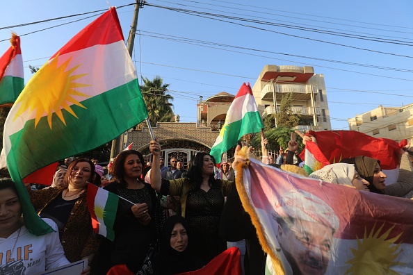 Les Kurdes syriens brandissent un portrait du leader kurde irakien Massoud Barzani alors qu'ils manifestent dans la ville syrienne de Qamishli le 23 octobre 2017 contre l'opération des forces irakiennes dans la ville multiethnique de Kirkouk et appellent la communauté internationale à défendre les régions kurdes en Irak.
La rapidité avec laquelle les troupes irakiennes ont accablé les forces kurdes cette semaine à Kirkouk, riche en pétrole, quelques jours après l'éviction du groupe terroriste État islamique, marque un changement radical dans l'équilibre du pouvoir, selon les analystes. 
Le mandat de M. Barzani, premier et unique président élu de la région autonome du nord de l'Irak, a expiré en 2013. Il a été prolongé de deux ans, puis s'est poursuivi dans le chaos créé par la percée fulgurante du groupe terroriste État islamique (EI) en 2014.
(DELIL SOULEIMAN / AFP / Getty Images)

