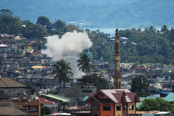Une explosion contrôlée par l'armée et des bâtiments détruits dans la zone de combat principale de Marawi sur l'île de Mindanao le 24 octobre 2017, un jour après que les militaires ont déclaré les combats. Les habitants de cette ville du sud des Philippines, où les partisans du groupe terroriste État islamique ont mené une brutale bataille de cinq mois, ont commencé à rentrer chez eux le 24 octobre. (TED ALJIBE / AFP / Getty Images)
