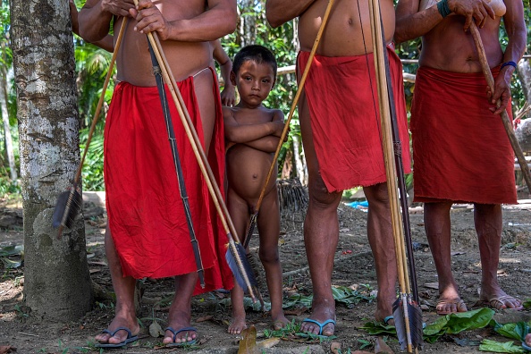 Un garçon Waiapi se tient derrière les adultes au village Pinoty dans la réserve indigène Waiapi dans l'état d'Amapa au Brésil le 12 octobre 2017. Le chef tribal Tzako Waiapi se souvient parfaitement du jour où son groupe de chasse a trébuché sur un groupe d'aventuriers blancs dans la forêt amazonienne. En quelques mois, presque tout le monde dans sa tribu était mort d'une maladie.
(APU GOMES / AFP / Getty Images)
