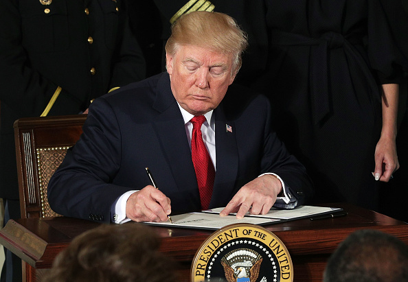 Le président américain Donald Trump signe un document.
(Alex Wong / Getty Images)