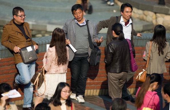 Des Chinois et des Chinoises célibataires bavardent alors que des milliers de personnes seules se sont rassemblées dans l’espoir de trouver leur partenaire lors d’une foire de célibataires organisée par l’agence de  mariage à Shanghai,  le 12 novembre 2011. (STR / AFP / Getty Images)