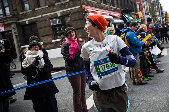 Marathon de New York, Elizabeth Mueller de San Francisco recommence à courir le TCS New York City Marathon après s'être arrêtée pour dire bonjour à ses amis le 2 novembre 2014 dans le quartier de Park Slope du Brooklyn Borough à New York. 
(Andrew Burton / Getty Images)