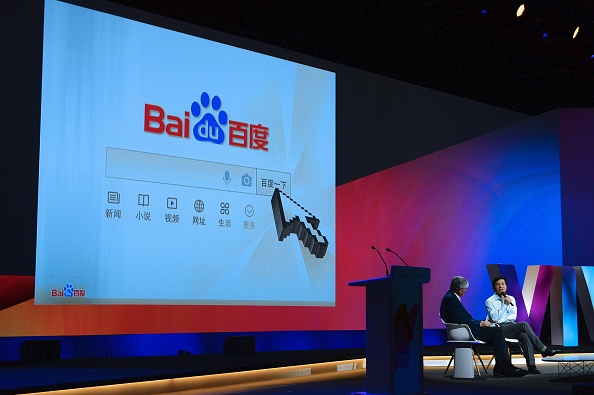 Robin Li (D), fondateur et président-directeur général de Baidu, parle à Maurice Levy, lors de l'évènement technologique Viva à Paris le 1er juillet 2016. 
(ERIC PIERMONT / AFP / Getty Images)