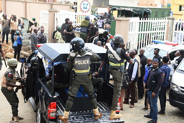 Des policiers anti-émeutes nigérians escortent Chukwudubem Onwuamadike, connu sous le nom d'Evans, soupçonné d'enlèvement. Il a plaidé coupable aux accusations de kidnapping après avoir été traduit en justice avec cinq autres complices 
(PIUS UTOMI EKPEI / AFP / Getty Images)