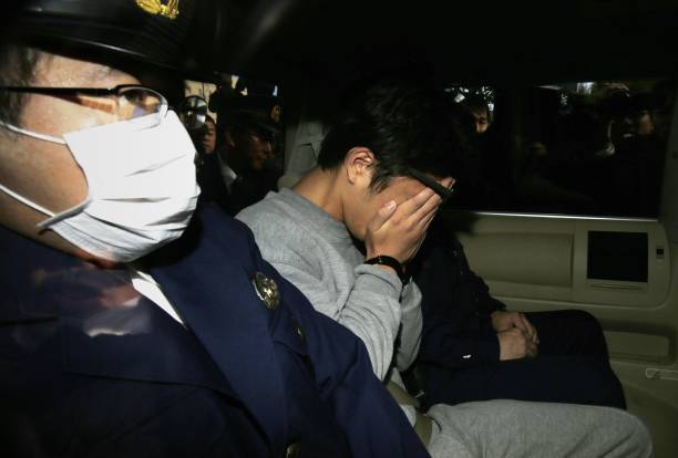 Le suspect Takahiro Shiraishi (C) couvre son visage avec ses mains alors qu'il est transporté au bureau du procureur depuis un poste de police à Tokyo le 1er novembre 2017. Le Japonais de 27 ans, arrêté après que la police a trouvé neuf cadavres démembrés en train de pourrir dans sa maison, a avoué avoir tué toutes ses victimes au cours d'une frénésie de deux mois après les avoir contactés via Twitter, les médias. 
(STR / AFP / Getty Images)