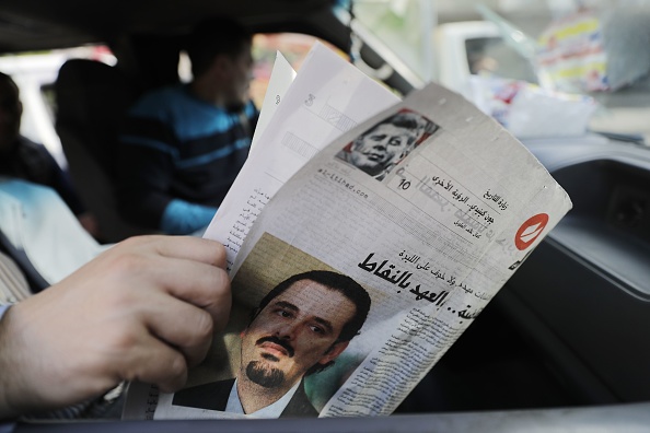 Un libanais tient un journal avec le portrait de l'ancien Premier ministre libanais. Saad Hariri avait donné sa démission le 6 novembre 2017. Hariri a depuis indiqué qu'il pourrait "revoir sa démission" si les interventions de certains acteurs libanais dans les conflits régionaux cessaient.
(JOSEPH EID / AFP / Getty Images)