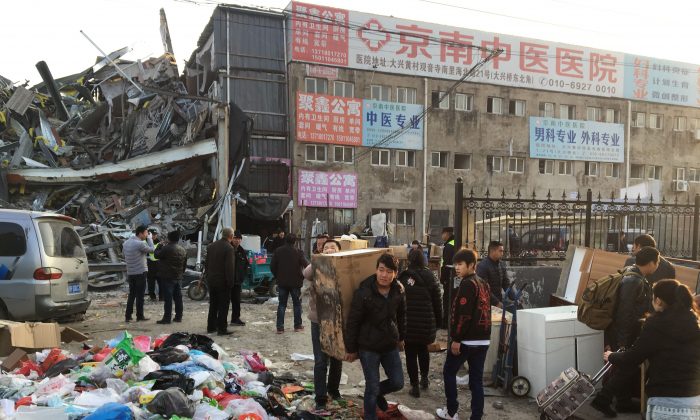 Les résidents évacuent leurs biens après un incendie  mortel d’un immeuble à Pékin, le 19 novembre 2017. (RYAN MCMORROW / AFP / Getty Images)