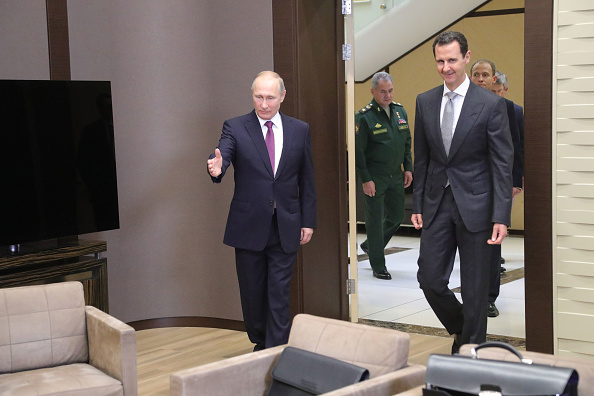 Le président russe Vladimir Poutine montre le chemin à son homologue syrien Bashar al-Assad lors d'une réunion à Sotchi le 20 novembre 2017. /
(MIKHAIL KLIMENTYEV / AFP / Getty Images)