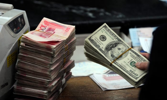 Une pile de dollars américains et des piles de billets de 100 yuans dans une banque dans la ville de Hefei, province de l'Anhui, à l'est de la Chine, le 9 mars 2010. (STR / AFP / Getty Images)