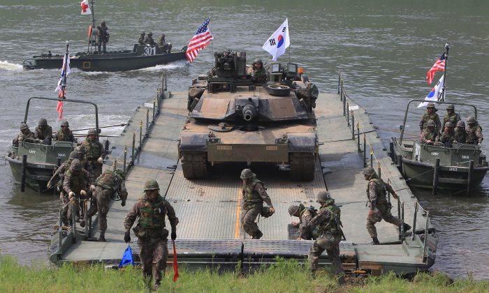 Des soldats américains et sud-coréens suivis par un char américain M1A2 lors de l’exercice de traversée d’un fleuve à Yeoncheon-gun, Corée du Sud, le 30 mai 2013. Au cours des derniers mois, la Corée du Sud et les États-Unis ont tenu plusieurs exercices militaires conjoints. (Chung Sung-Jun / Getty Images)