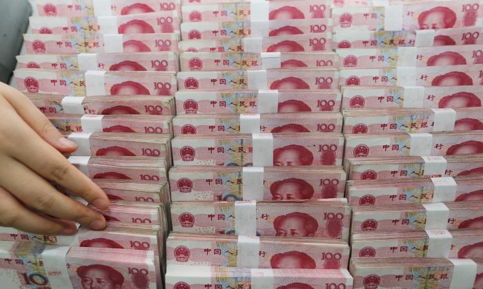 Une caissière compte des billets de yuans dans une banque à Lianyungang, province du Jiangsu, le 11 août 2015. (STR / AFP / Getty Images)