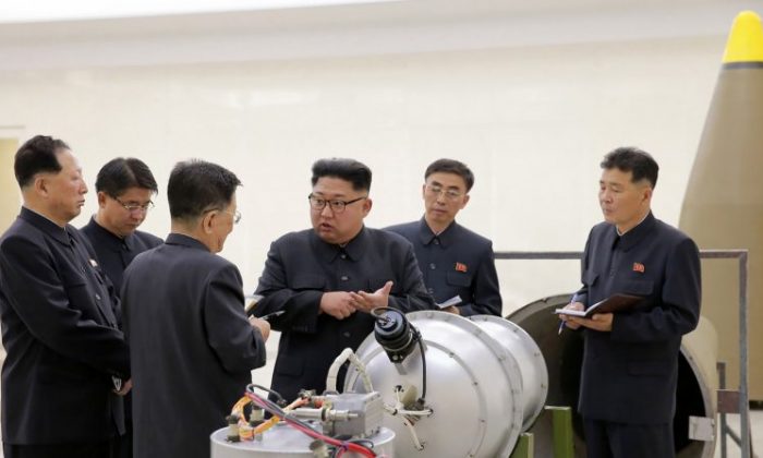 Cette photo non datée, publiée le 3 septembre 2017 par l'Agence centrale de presse coréenne officielle de Corée du Nord (KCNA), présente le leader nord-coréen Kim Jong-un (C) examinant un boîtier métallique avec deux bombements à un endroit non divulgué. (STR/AFP/Getty Images)