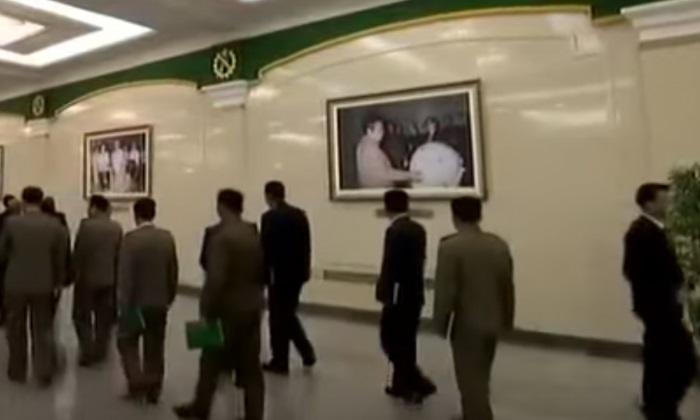 Lors d'une conférence sur les armes de Pyongyang, le 11 décembre 2017, une photo accrochée dans le hall montre le dirigeant nord-coréen Kim Jong Il en train d'examiner ce qui pourrait être une bombe atomique miniaturisée. (Capture d'écran via Stimme Koreas/YouTube)