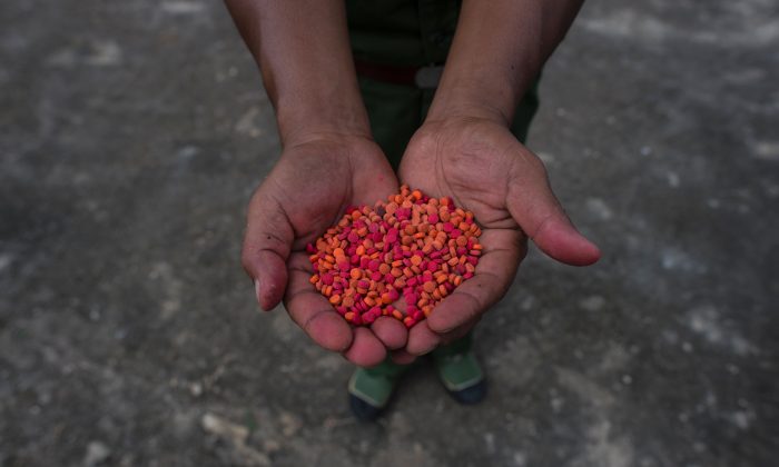 Les pilules de la drogue « yaba » ( méthamphétamine ) sont montrées avant d’être brûlées à Poung Par Khem, à la frontière entre la Thaïlande et le Myanmar, lors de la cérémonie à l’occasion de la Journée mondiale contre la drogue des Nations Unies, le 26 juin 2017. (Ye Aung Thu / AFP / Getty Images )