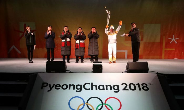 Le porteur du flambeau Yang Jung-Mo tient le flambeau des Jeux Olympiques d'hiver de PyeongChang 2018 , le 4 novembre 2017, à Busan, en Corée du Sud. (Photo de Chung Sung-Jun/Getty Images) 