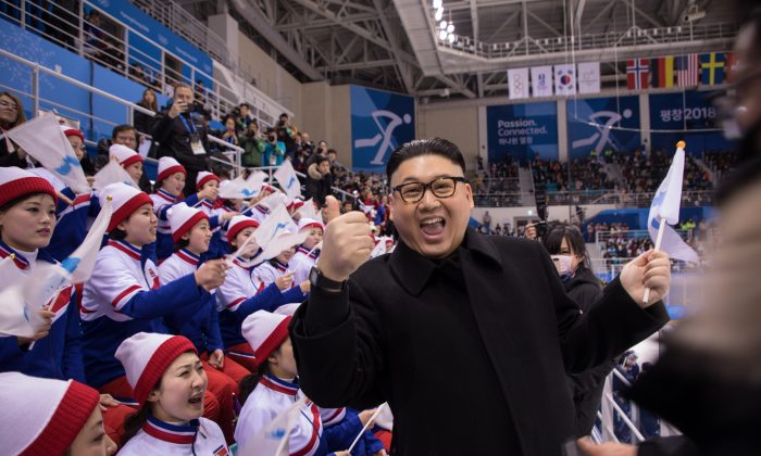 Un homme qui imite le dictateur nord-coréen Kim Jong-un pose devant les pom-pom girls nord-coréennes lors du match de hockey sur glace entre l’équipe coréenne unifiée et celle du Japon aux Jeux olympiques d'hiver 2018 de Pyeongchang, Corée du Sud, le 14 février 2018. (YELIM LEE/AFP/Getty Images)