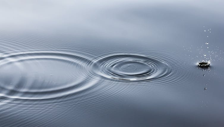 Comme une goutte d'eau venant perturber une surface lisse, les ondes gravitationnelles sont des rides de l'espace-temps. (Linus Nylund/Unsplash, CC BY-SA)