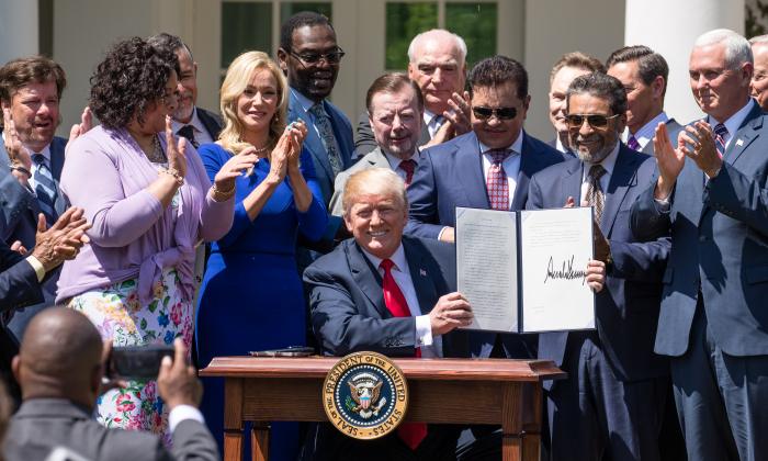 Le président Donald Trump signe un décret exécutif intitulé "Establishment of a White House Faith and Opportunity Initiative" lors de la Journée nationale de prière dans la roseraie de la Maison-Blanche à Washington le 3 mai 2018. (Samira Bouaou/The Epoch Times)