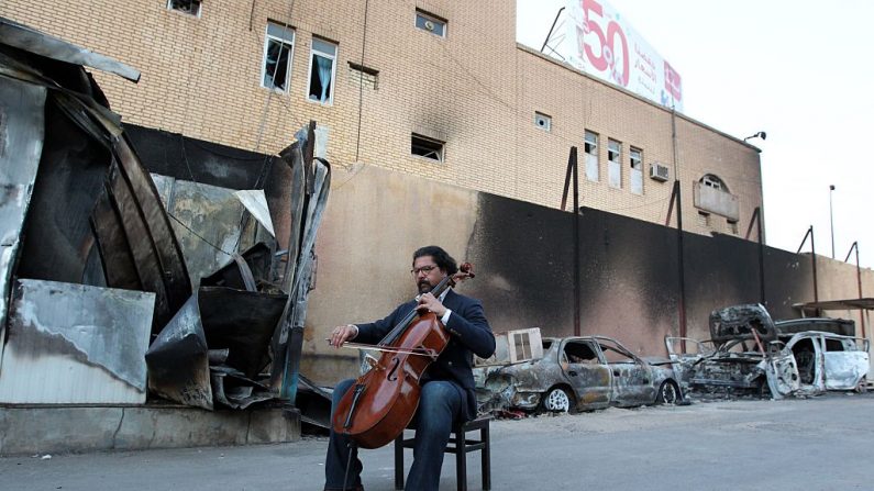 Karim Wasfi, ancien directeur de l'Orchestre symphonique national irakien, joue sur son violoncelle à côté des débris dans le quartier sunnite, dans un acte symbolique de protestation contre la violence. PHOTO SABAH ARAR / AFP / Getty Images.