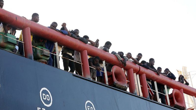      Des migrants clandestins se tiennent sur le pont d'un pétrolier libyen qui les a secourus au large de la capitale libyenne, Photo  MAHMUD TURKIA/AFP/Getty Images.