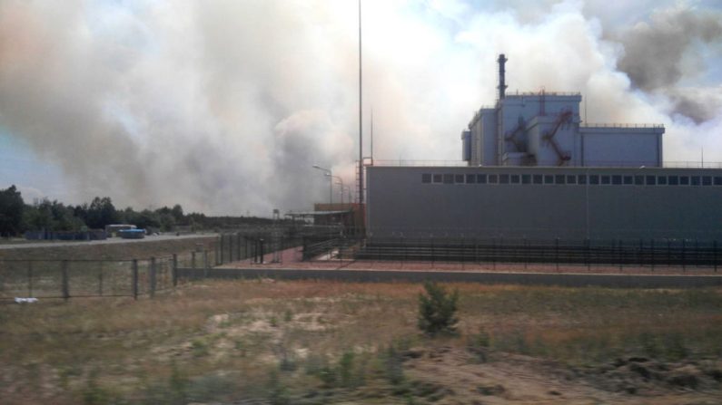 Une photo prise avec un mobile montre une fumée qui s'élève près de la centrale nucléaire de Tchernobyl le 4 juin 2018.   
 Photo  NATALKA LEVINA/AFP/Getty Images;