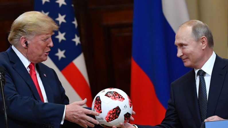 Le président russe Vladimir Poutine présente le ballon de la Coupe du monde de football 2018 au président américain Donald Trump lors d'une conférence de presse conjointe après une réunion au palais présidentiel d'Helsinki, le 16 juillet 2018. Photo YURI KADOBNOV/AFP/Getty Images.