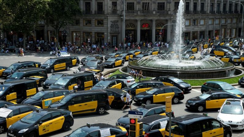 Les chauffeurs de taxi bloquent la Grande rue de Barcelone le 28 juillet 2018. Les chauffeurs de taxi de Madrid se sont mis en grève en signe de solidarité avec les chauffeurs de taxi de Barcelone qui protestent contre la « concurrence déloyale » d'Uber et Cabify. Photo JOSEP LAGO / AFP / Getty Images.