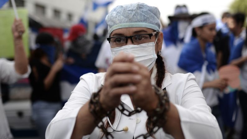 Un médecin congédié participe à la "Marche des moqueries" contre le président nicaraguayen Daniel Ortega et son épouse, la vice-présidente Rosario Murillo, à León, au Nicaragua, le 28 juillet 2018. - Une quarantaine de médecins, infirmières et techniciens d'un L'hôpital public nicaraguayen a été congédié. Photo MARVIN RECINOS / AFP / Getty Images.
