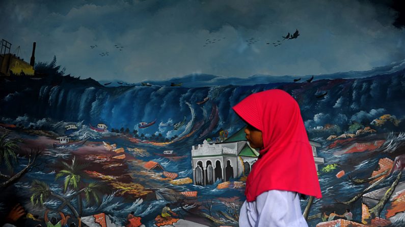 Une fresque du tsunami au cimetière où des milliers de victimes du tsunami de 2004 sont enterrées à Banda Aceh. Ce tsunami qui a tué quelque 220 000 personnes. Un séisme de magnitude 9,3 au large de la pointe occidentale de l'Indonésie a généré une série de vagues massives qui ont détruit le littoral de 14 pays aussi éloignés que l'Indonésie, la Thaïlande, le Sri Lanka et la Somalie. Photo CHAIDEER MAHYUDDIN / AFP / Getty Images.