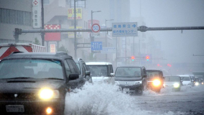 Une rue inondée bien que le typhon Jongdari s’est transformé en tempête tropicale, déversant des pluies torrentielles sur la région. Plus de 170 vols intérieurs ont été annulés ce dimanche.29/07/2018. Photo JIJI PRESS / AFP / Getty Images.