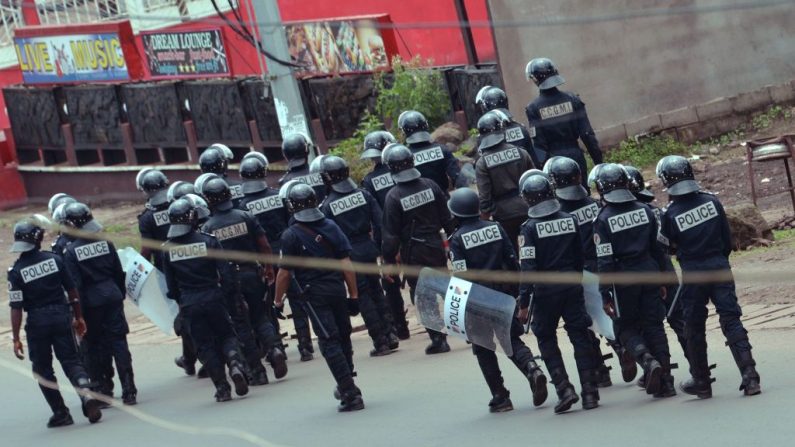 Des policiers camerounais marchent avec des boucliers antiémeute dans une rue du quartier administratif de Buea. Le révérend Fr. Alexander N. Sob a été abattu près de Muyuka (à 25 km au nord-est de Buea) hier 20 juillet 2018. Photo STR / AFP / Getty Images.