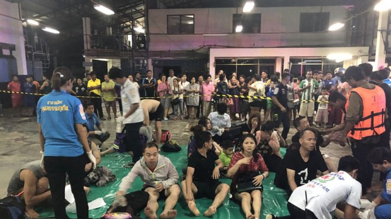 Le 5 juillet 2018, des passagers thaïlandais et des paramédicaux assistent les passagers rescapés d'un bateau touristique qui a chaviré dans le port de Phuket. Des dizaines de passagers sont portés disparus Photo KRITSADA MUENHAWONG / AFP / Getty Images.
